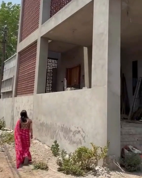 A two-storey home with brick-jaali screens and exposed concrete frame, under construction